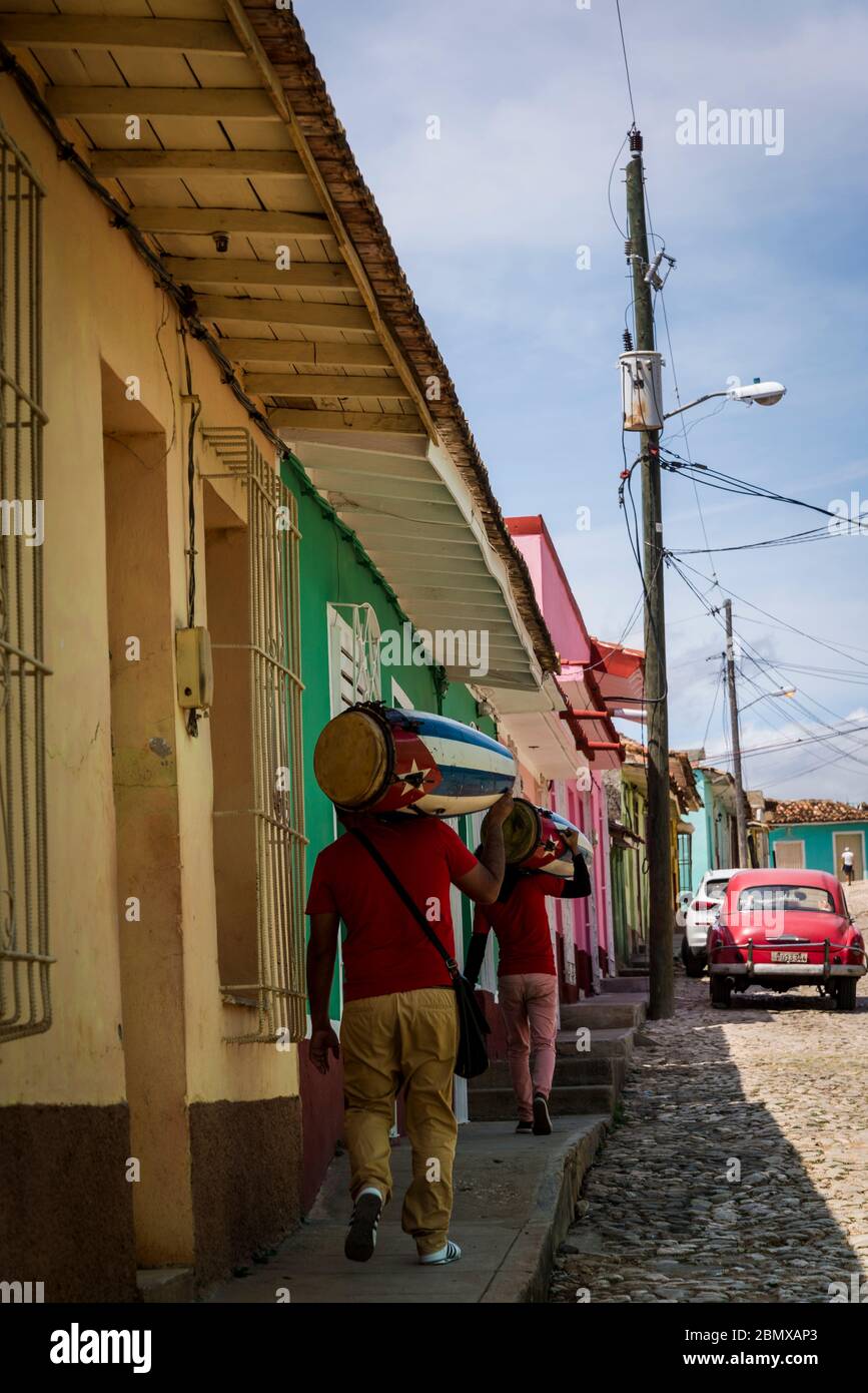 Musicians carrying drums in the old colonial centre of the town, Trinidad, Cuba Stock Photo