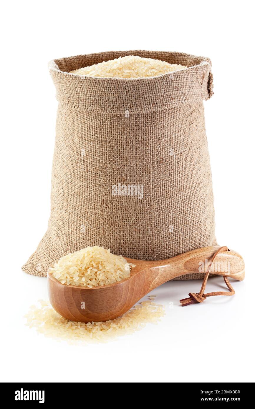 Rice in burlap sack and woodenware, isolated on the white background. Stock Photo