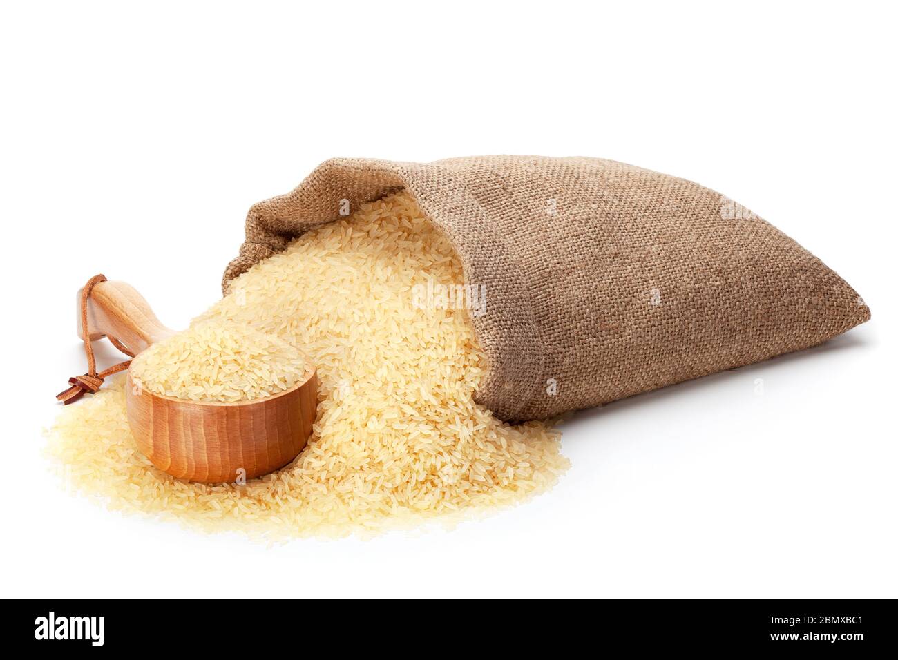 Rice in burlap sack and woodenware, isolated on the white background. Stock Photo