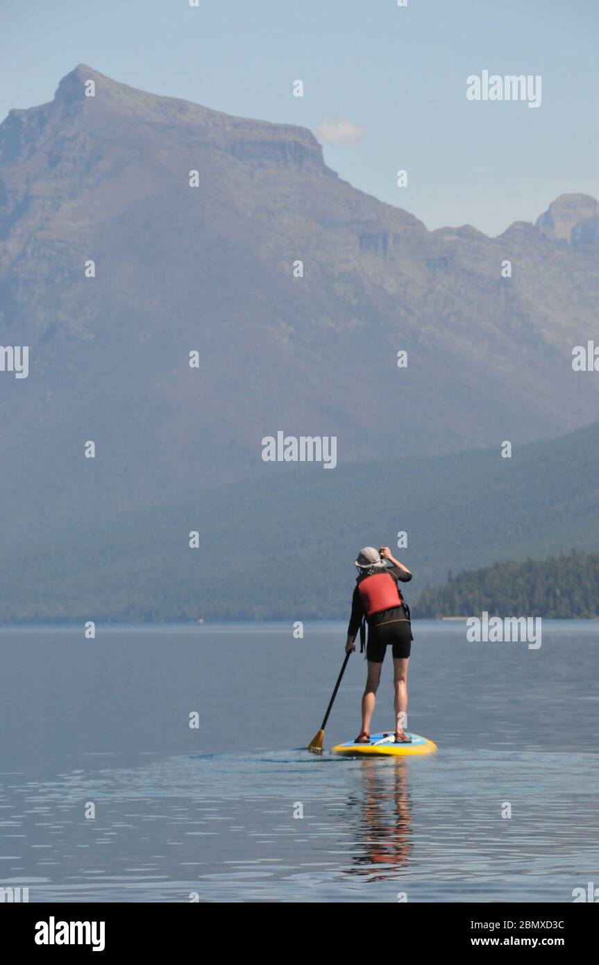 A stand up paddler on Lake McDonald, Glacier National Park, Montano, USA Stock Photo