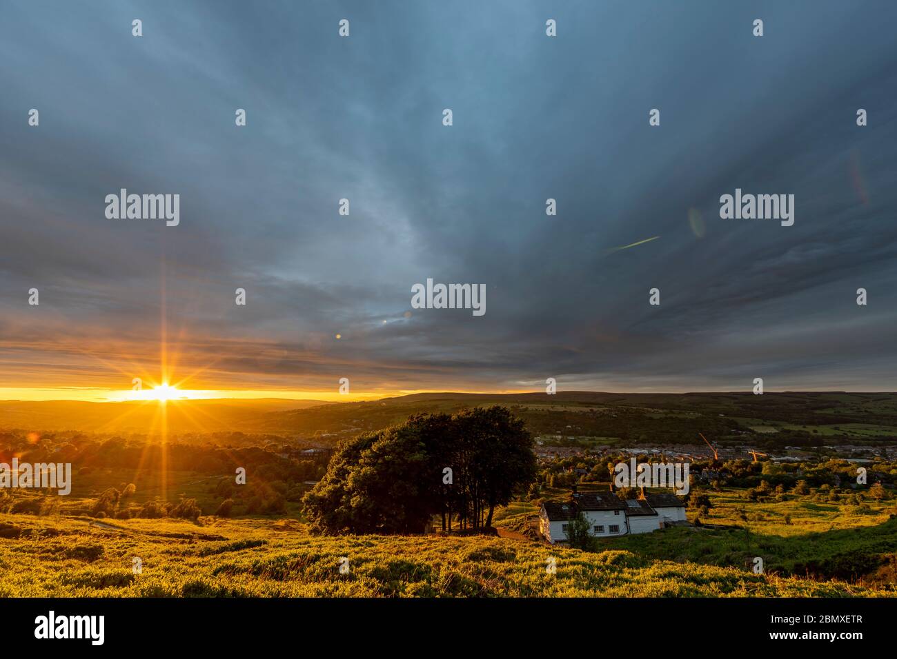 Dramatic Stormy Sunset over Ilkley by White Wells Spa Cottage on Ilkley Moor, Yorkshire, United Kingdom Stock Photo