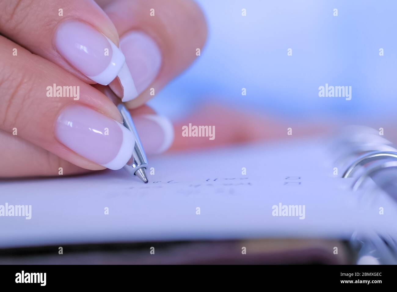 Woman hand holding pen and writing to do list in vintage notebook ...