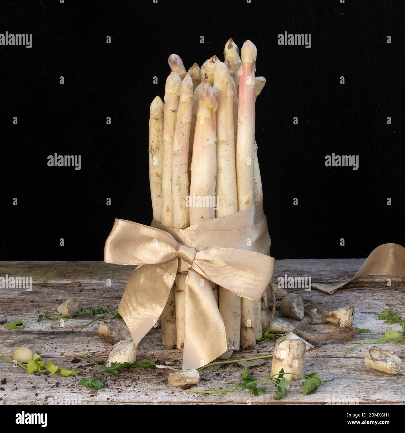 white asparagus side view on wooden table with black background Stock Photo