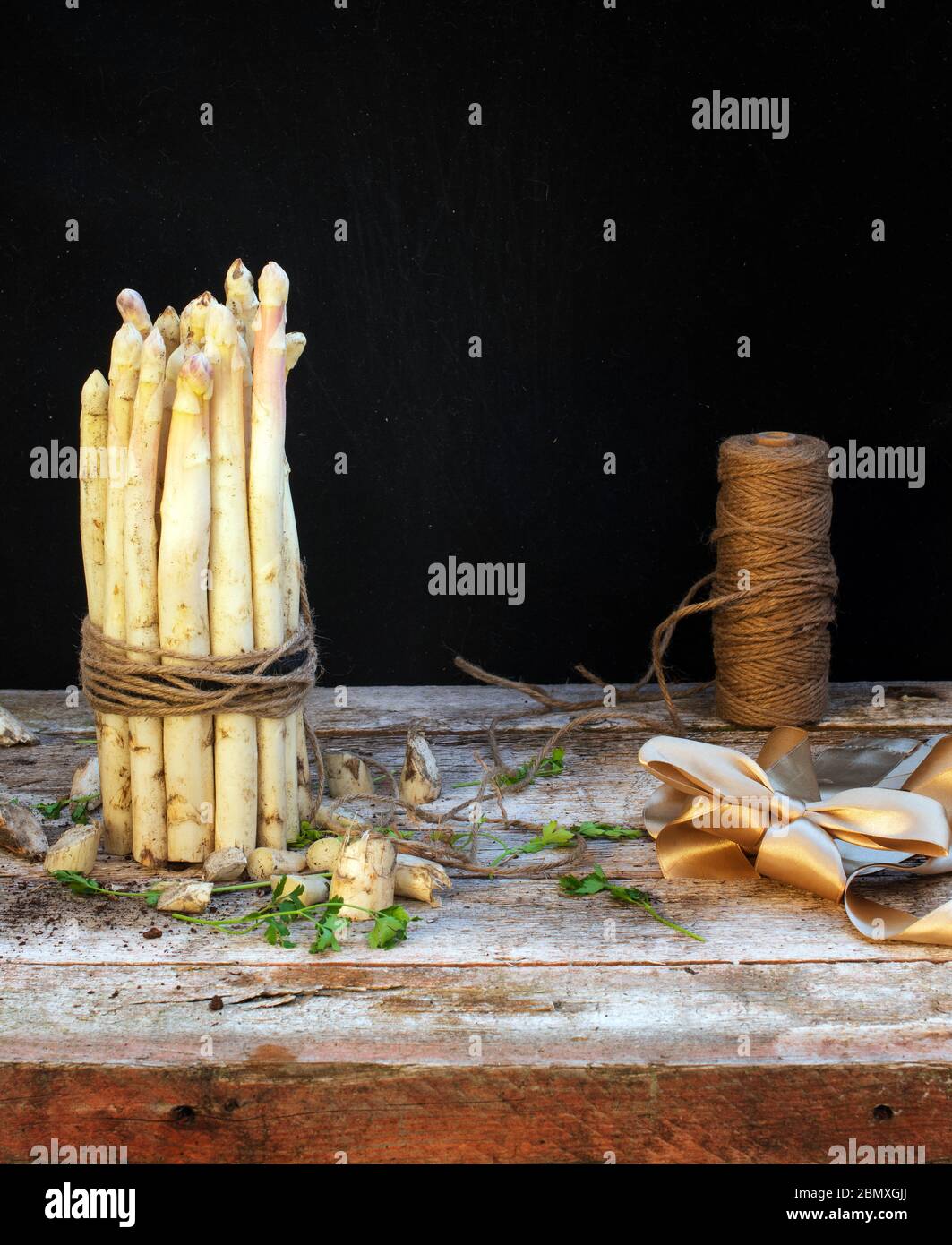 white asparagus side view on wooden table with black background Stock Photo