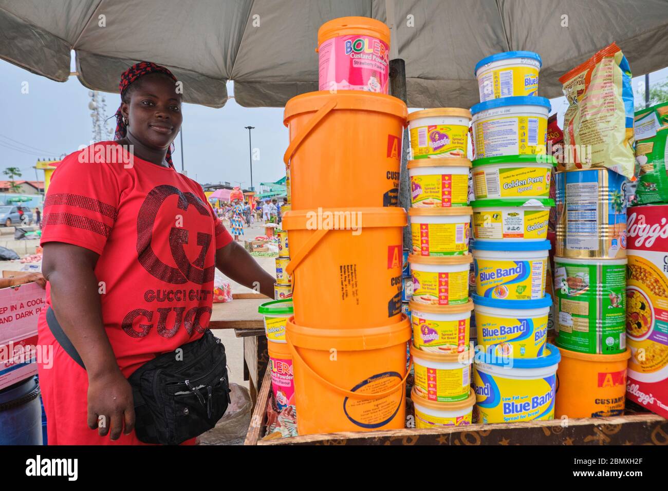 A grocery seller pose for a photo at a makeshift market where she sells