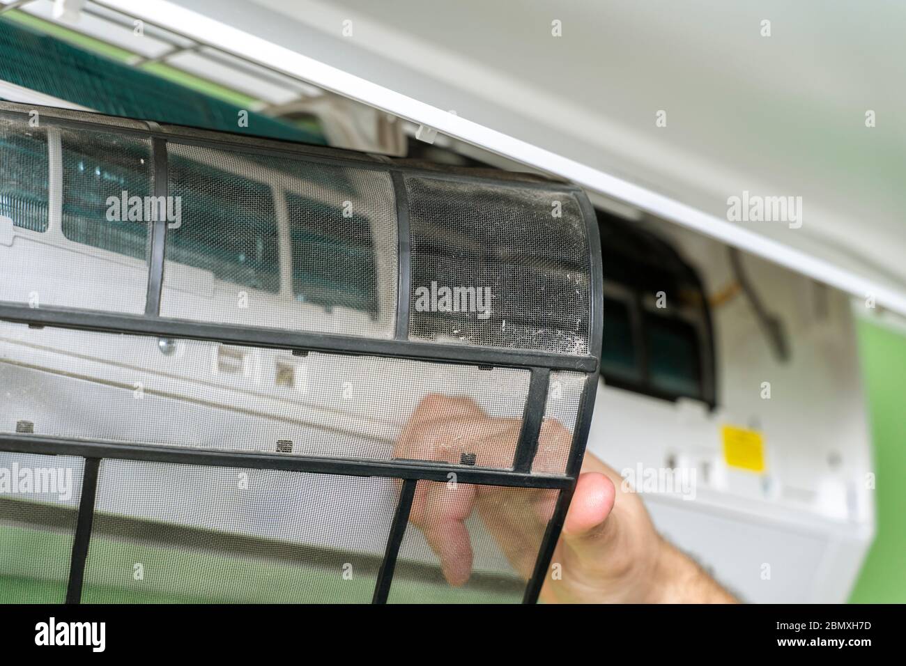 Male technician repairing and reading air conditioners. Cover opening and close-up of one filter Stock Photo