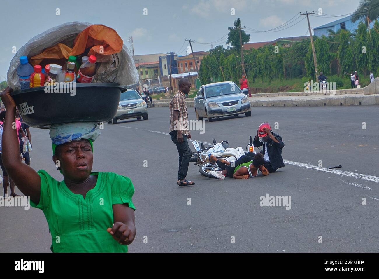 A hawker moves away from the scene of a road accident in Lagos, Nigeria. Stock Photo