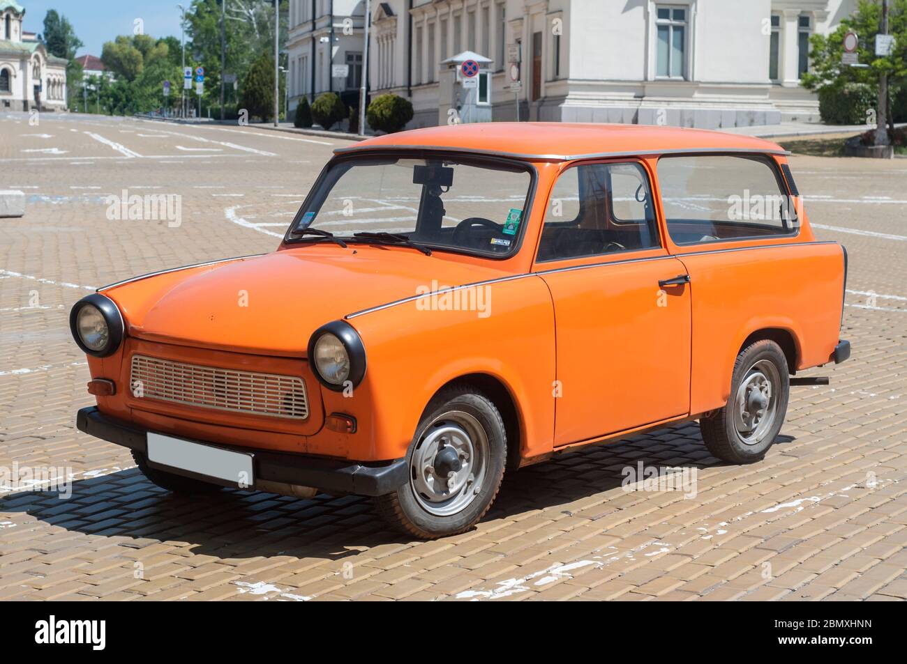 Orange colored vintage restored Trabant car on paved street Stock Photo