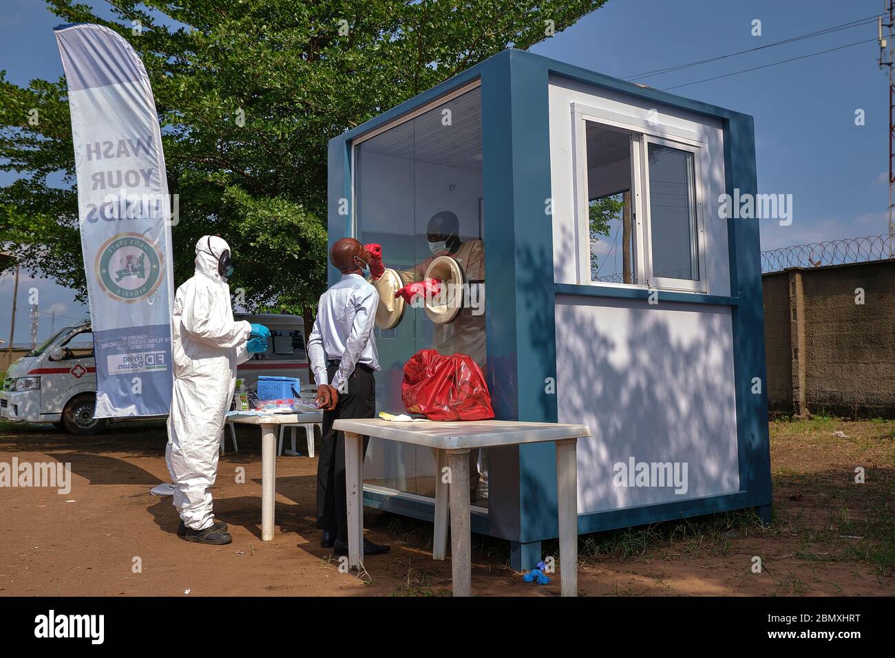A medical doctor takes a swab from a patient at a Covid-19 Test Sample Collection Centre in Ogun State, Nigeria. Stock Photo