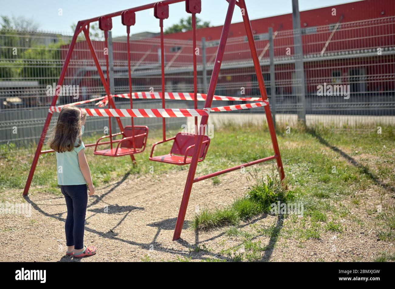 Alone Girl and Children's Swings  Wrapped With Signal Tape Stock Photo