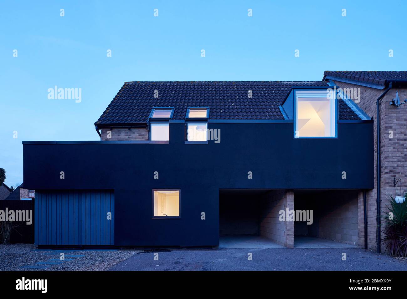 Front Elevation with deep black render at dusk. Cut & Wrap House, Hemel