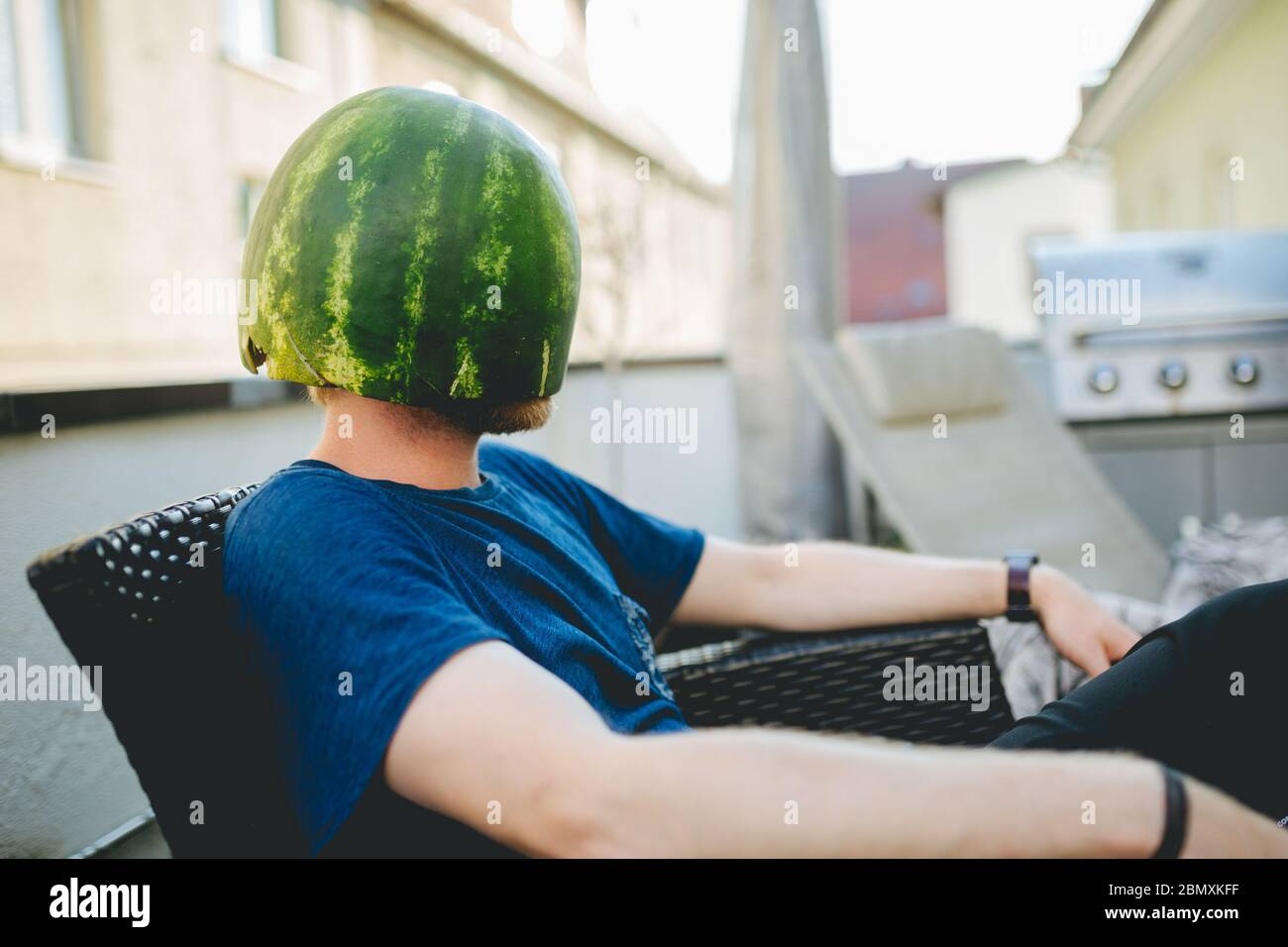 Man wearing a melon as a helmet Stock Photo Alamy