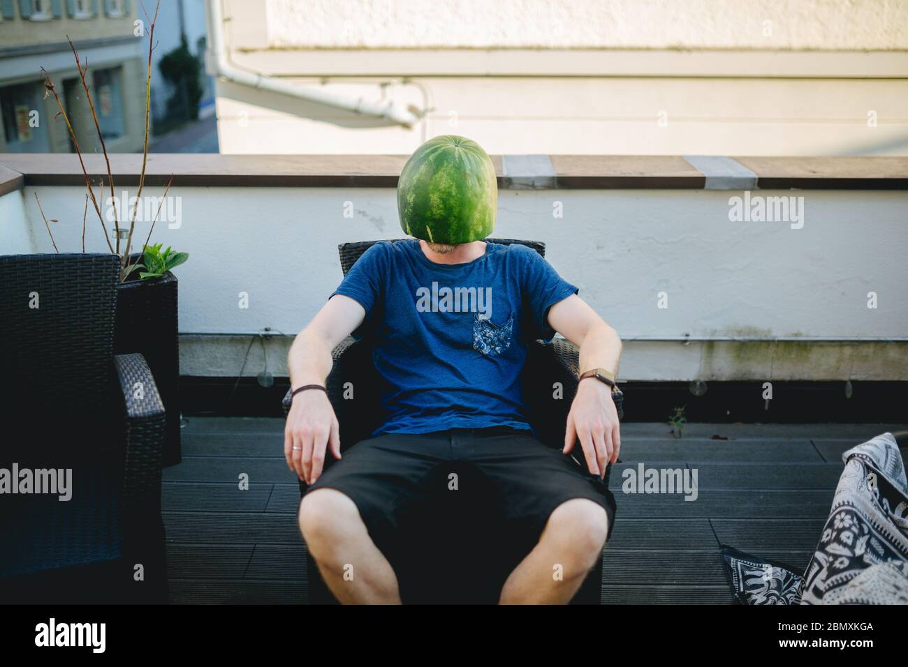 Man wearing a melon as a helmet Stock Photo Alamy