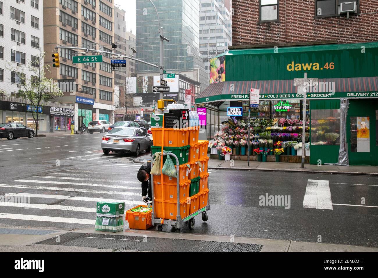 Delivery worker checking container contents on a rainy day in New York City. Stock Photo