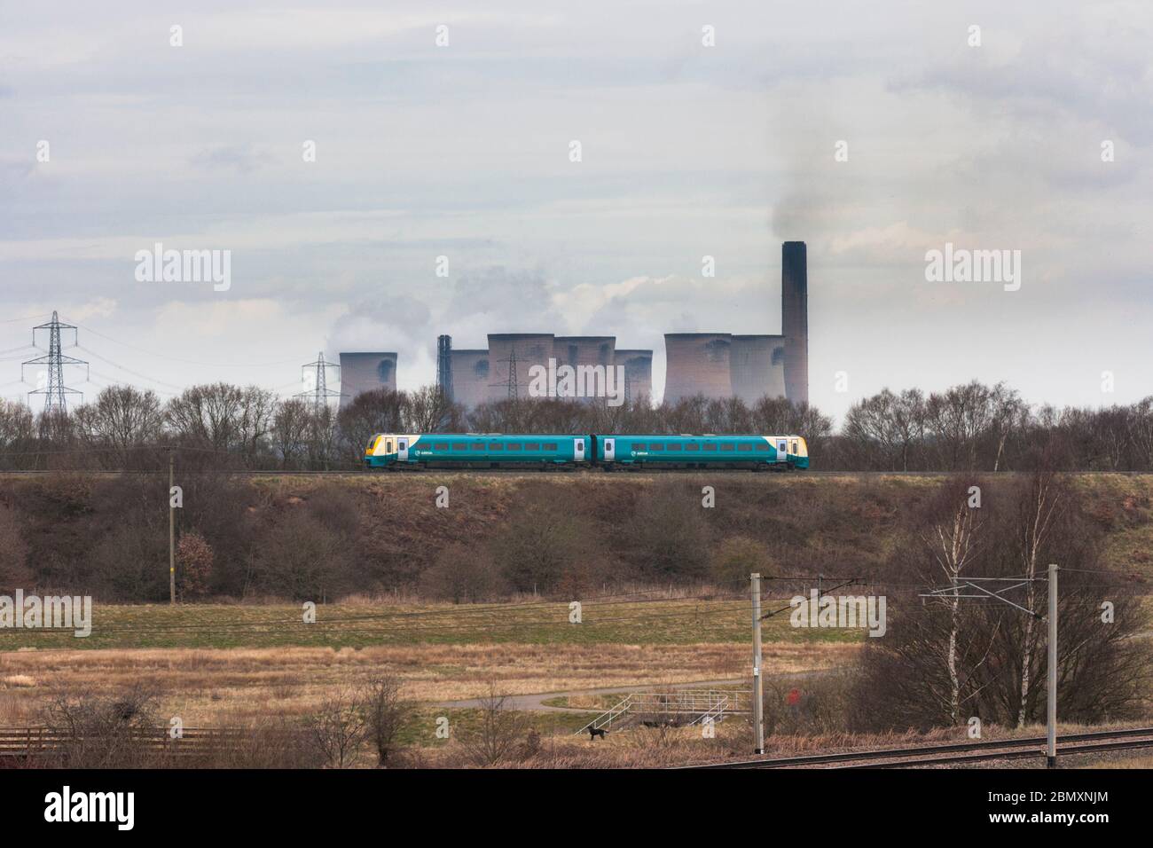 Arriva trains Wales class 175 Alstom Coradia train passing Daresbury, south of Warrington with Fiddlers Ferry power station cooling towers  behind Stock Photo