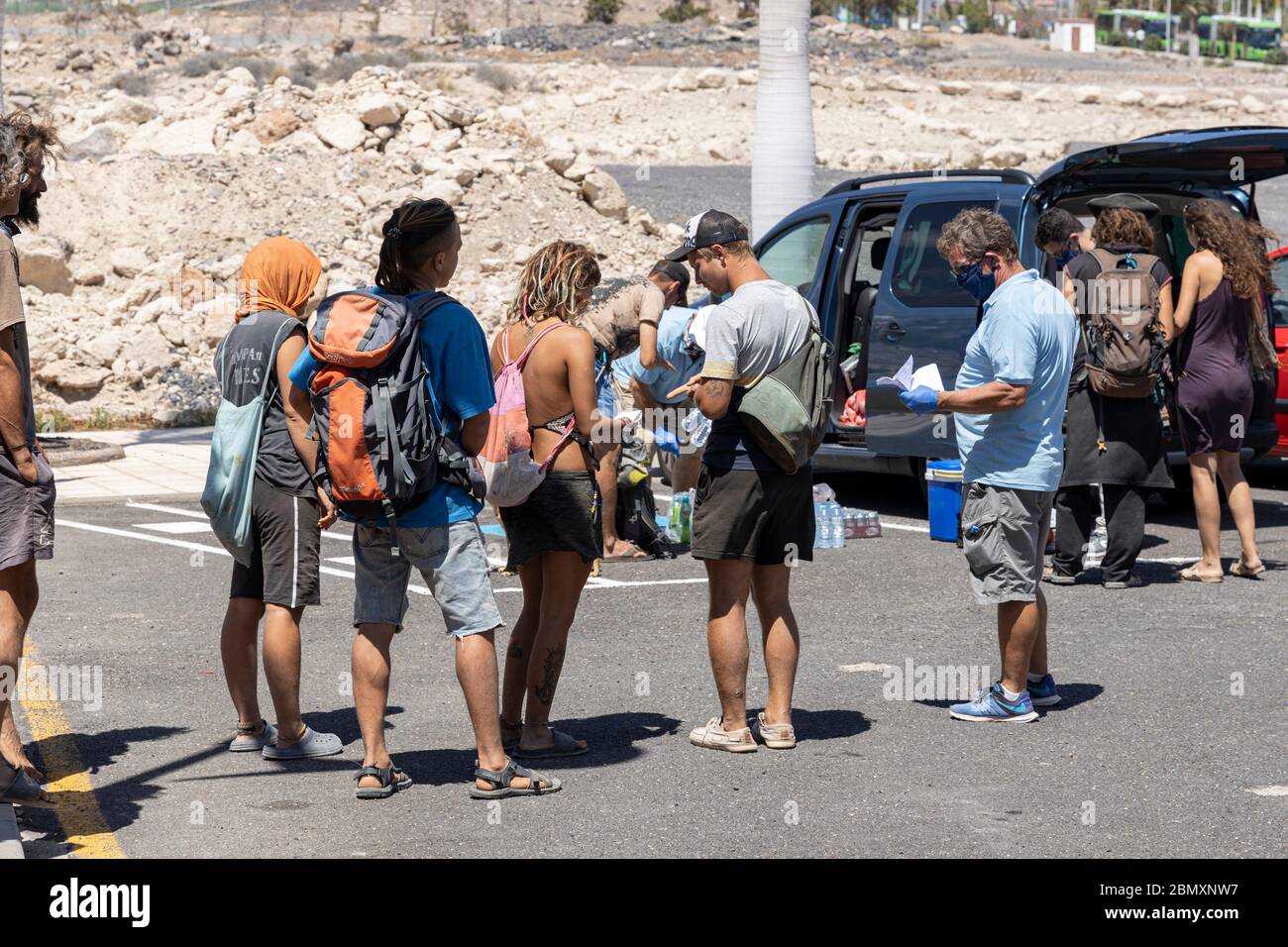 La Caleta, Costa Adeje, Tenerife, Canary Islands. 11 May 2020. Food bank charity El Arca de Noe, Noahs Ark, run by British residents provide food, water and soft drinks to a group of homeless people living rough along the Costa Adeje coastline. They rely on donations from local businesses and distribute basic foodstuffs to over a hundred people three times a week. Stock Photo
