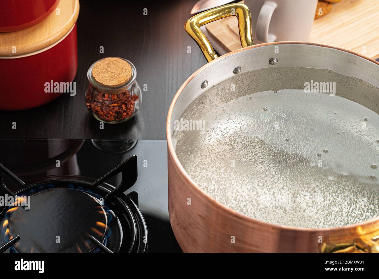Copper pot with boiling water on a gas stove Stock Photo Alamy