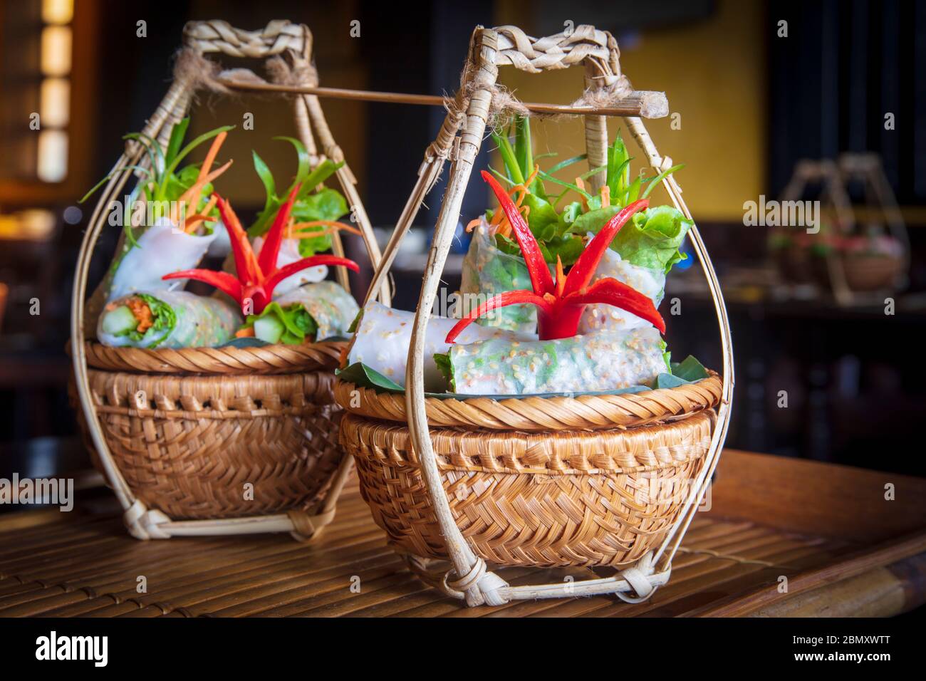 Vietnamese food served in traditional wicker baskets in a restaurant in Hoi An Stock Photo