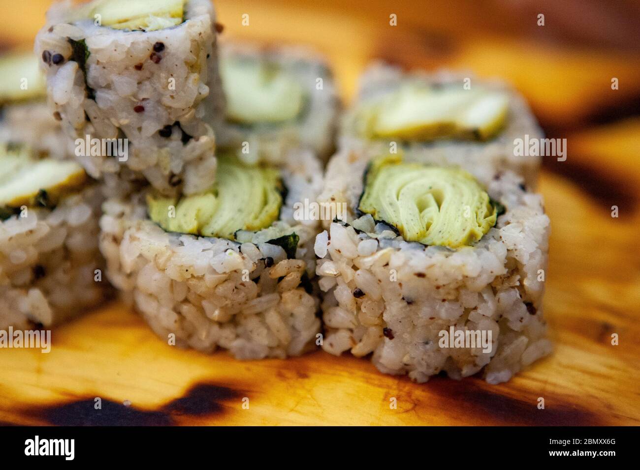 A selection of plant-based vegetable sushi rolls sits on a wooden platter at Miya's Sushi in New Haven, CT, USA Stock Photo