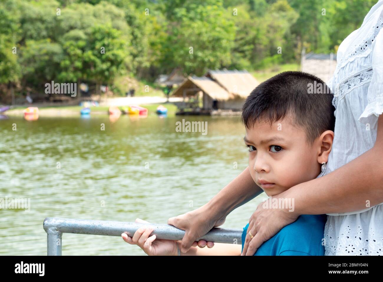 Portrait of a boy and The wooden raft in the water reservoirs. Stock Photo