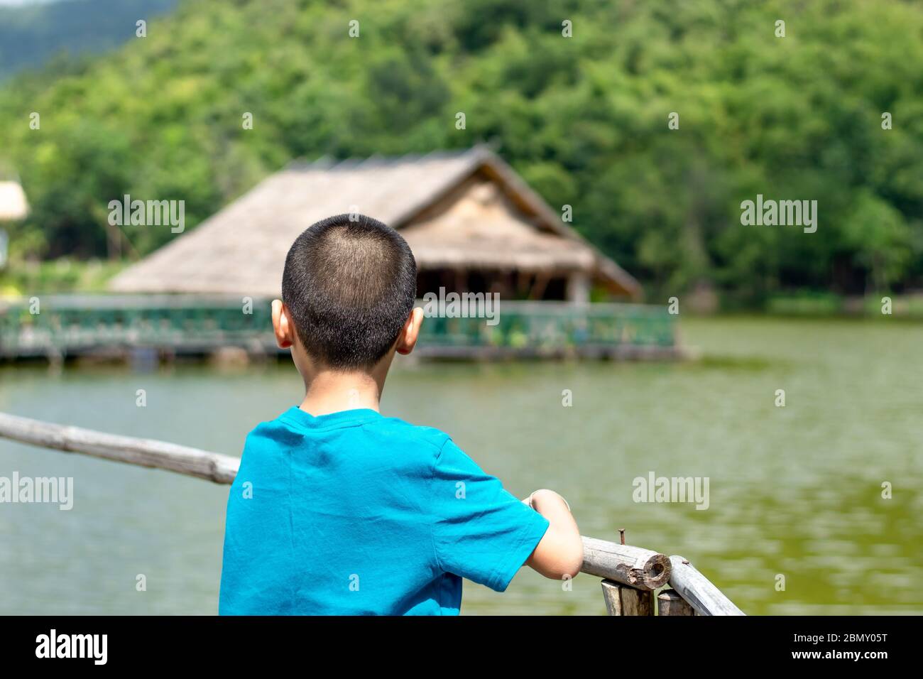 Portrait of a boy and The wooden raft in the water reservoirs. Stock Photo