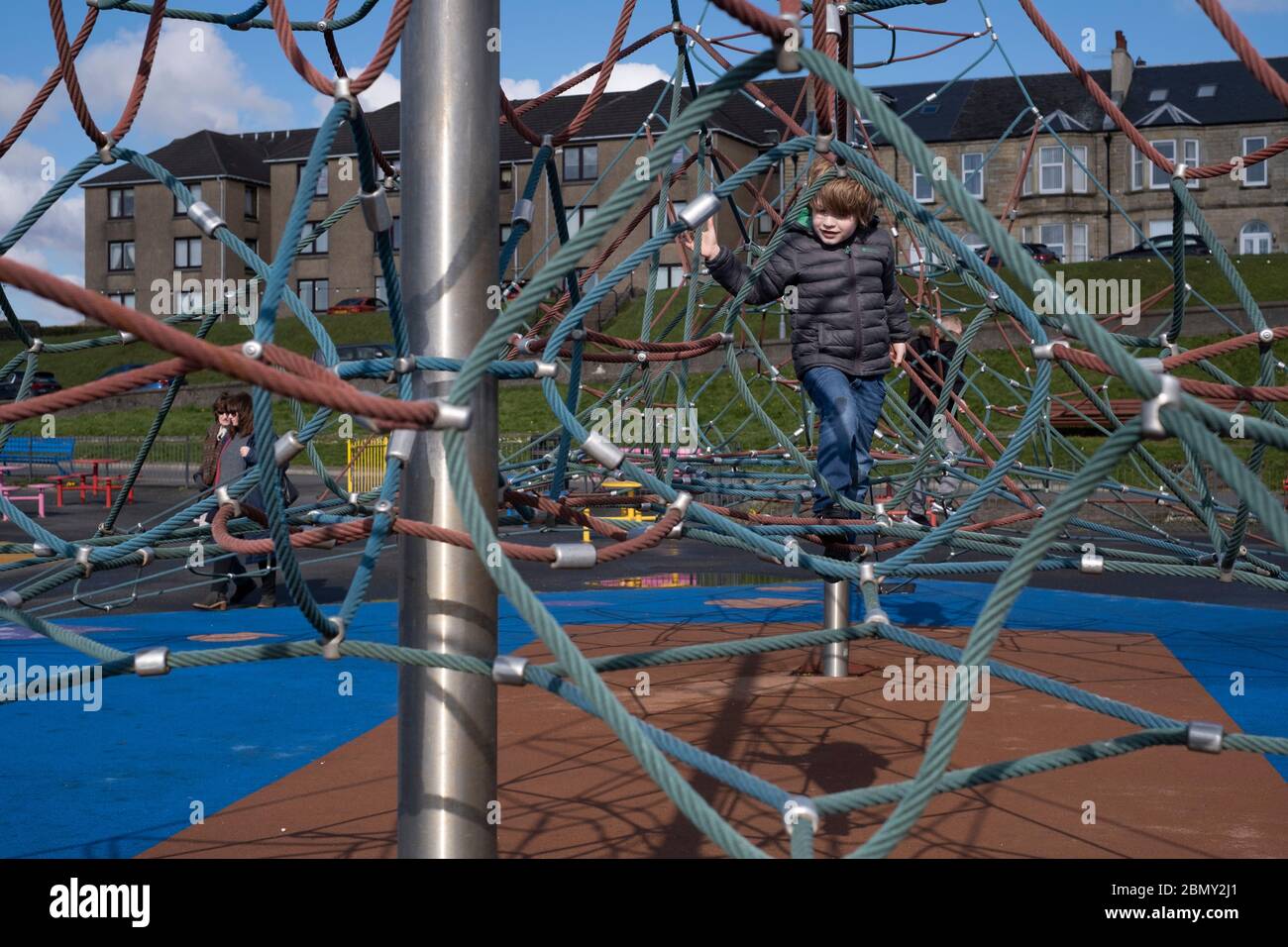 A young boy playing on a climbing frame. Stock Photo