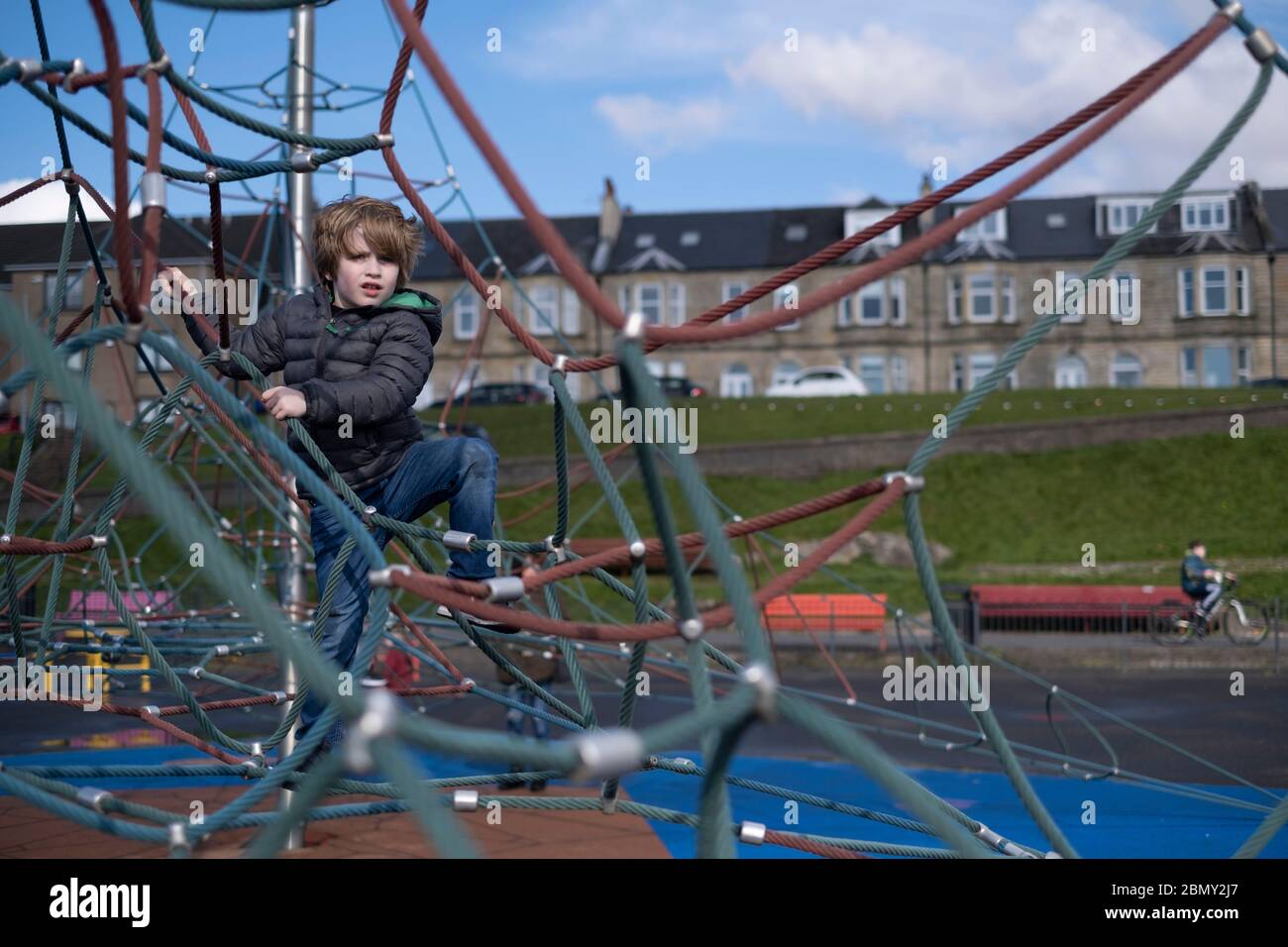 A young boy playing on a climbing frame. Stock Photo