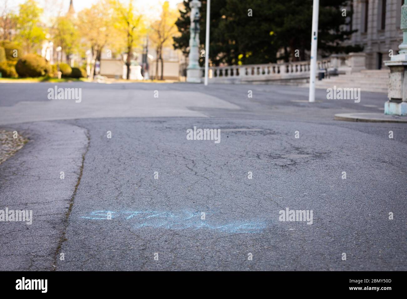stay home message written with blue chalk on a pathway in Vienna Stock Photo