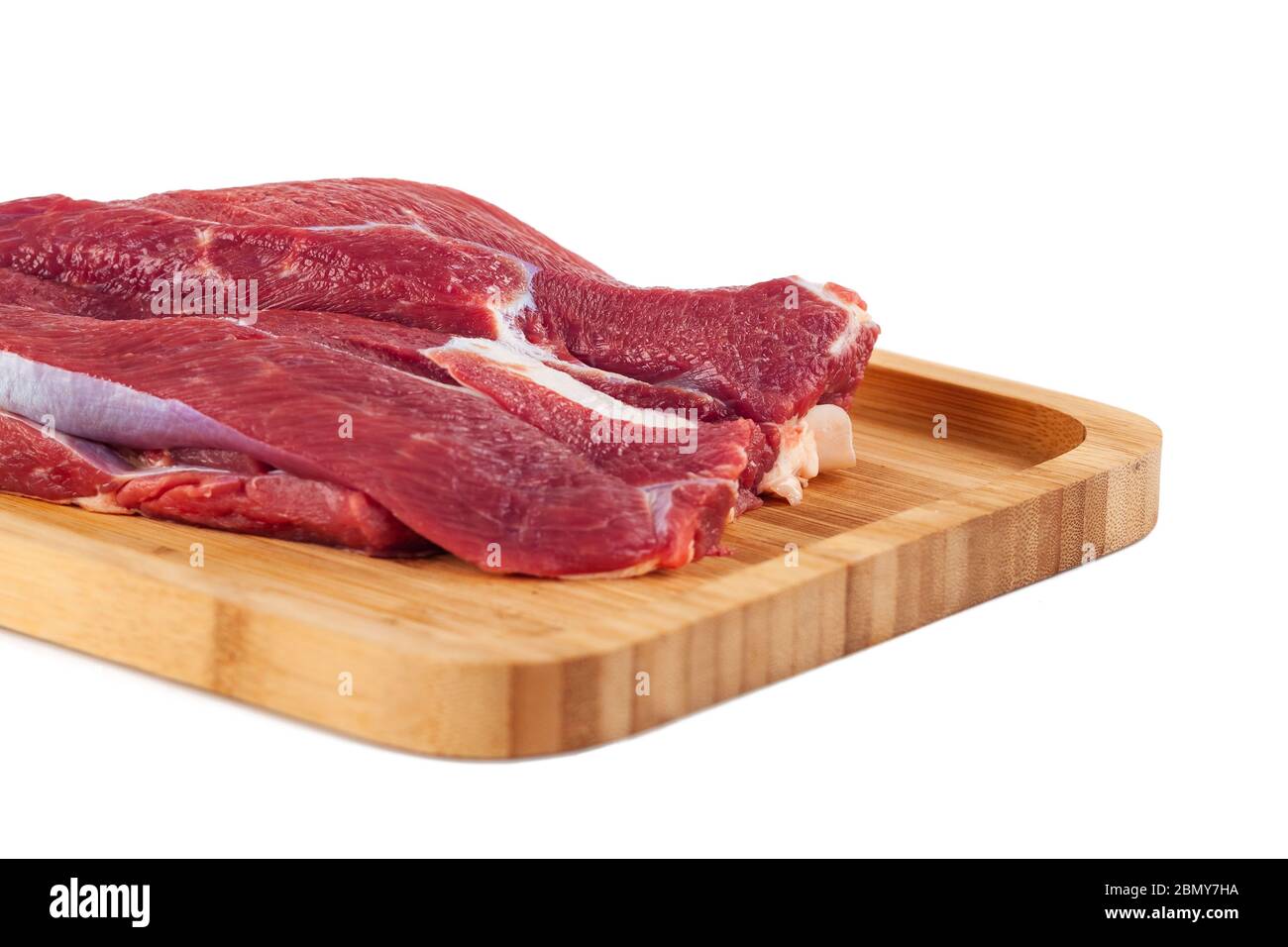 Raw meat on wooden board isolated on white background Stock Photo - Alamy