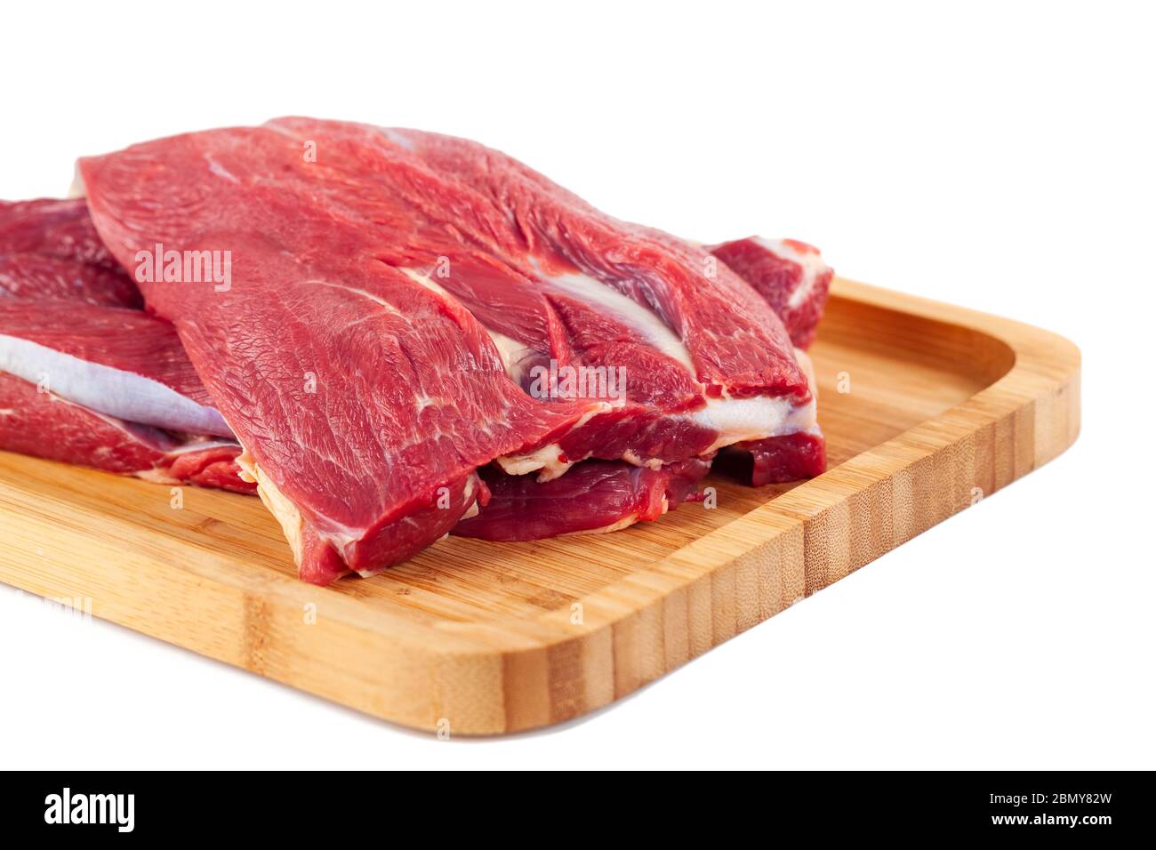 Raw meat on wooden board isolated on white background Stock Photo - Alamy