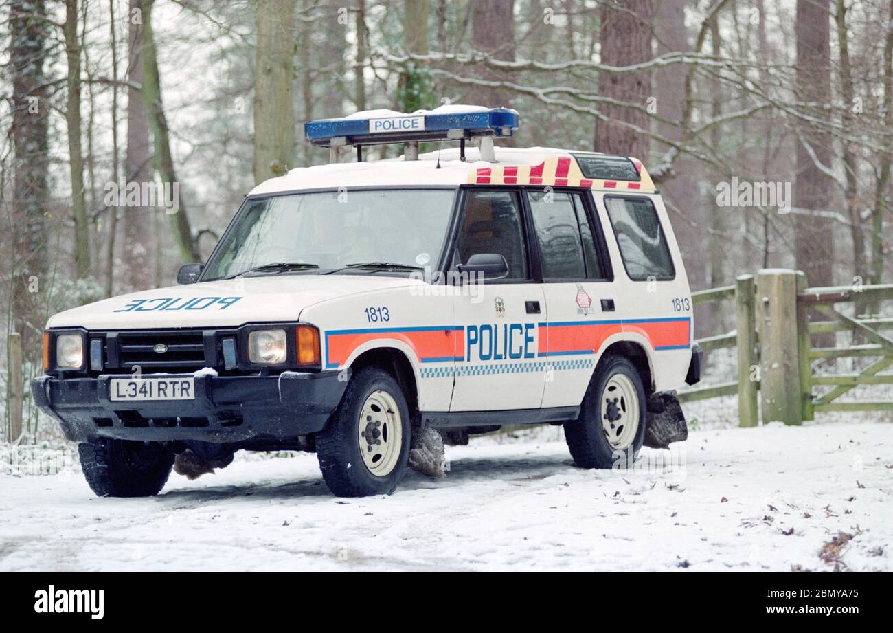 Hampshire Constabulary marked police cars on patrol in the Lyndhurst area of the New Forest during a winter snow fall, Lyndhurst, New Forest, Hampshire, England, UK Stock Photo