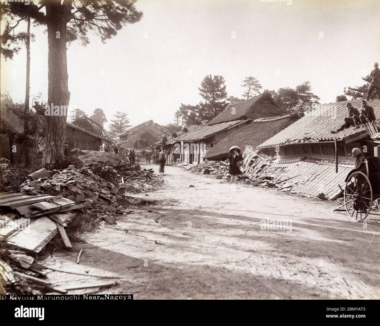[ 1890s Japan - Nobi Earthquake ] —   A road with homes devastated by the Nobi Earthquake (濃尾地震, Nobi Jishin) of October 28, 1891 (Meiji 24).  The Nobi Earthquake measured between 8.0 and 8.4 on the scale of Richter and caused 7,273 deaths, 17,175 casualties and the destruction of 142,177 homes.  The caption identifies the location as Kiyosu Marunouchi (清須丸ノ内) near Nagoya in Aichi Prefecture.  19th century vintage albumen photograph. Stock Photo