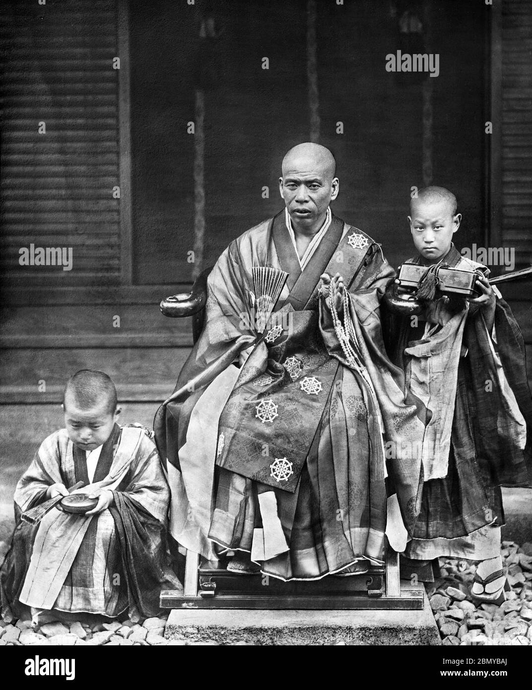 [ 1890s Japan - Buddhist Priest ] —   Buddhist Priest and Two Boys at a temple.  From a series of glass slides published (but not photographed) by Scottish photographer George Washington Wilson (1823–1893). Wilson’s firm was one of the largest publishers of photographic prints in the world.  19th century vintage glass slide. Stock Photo