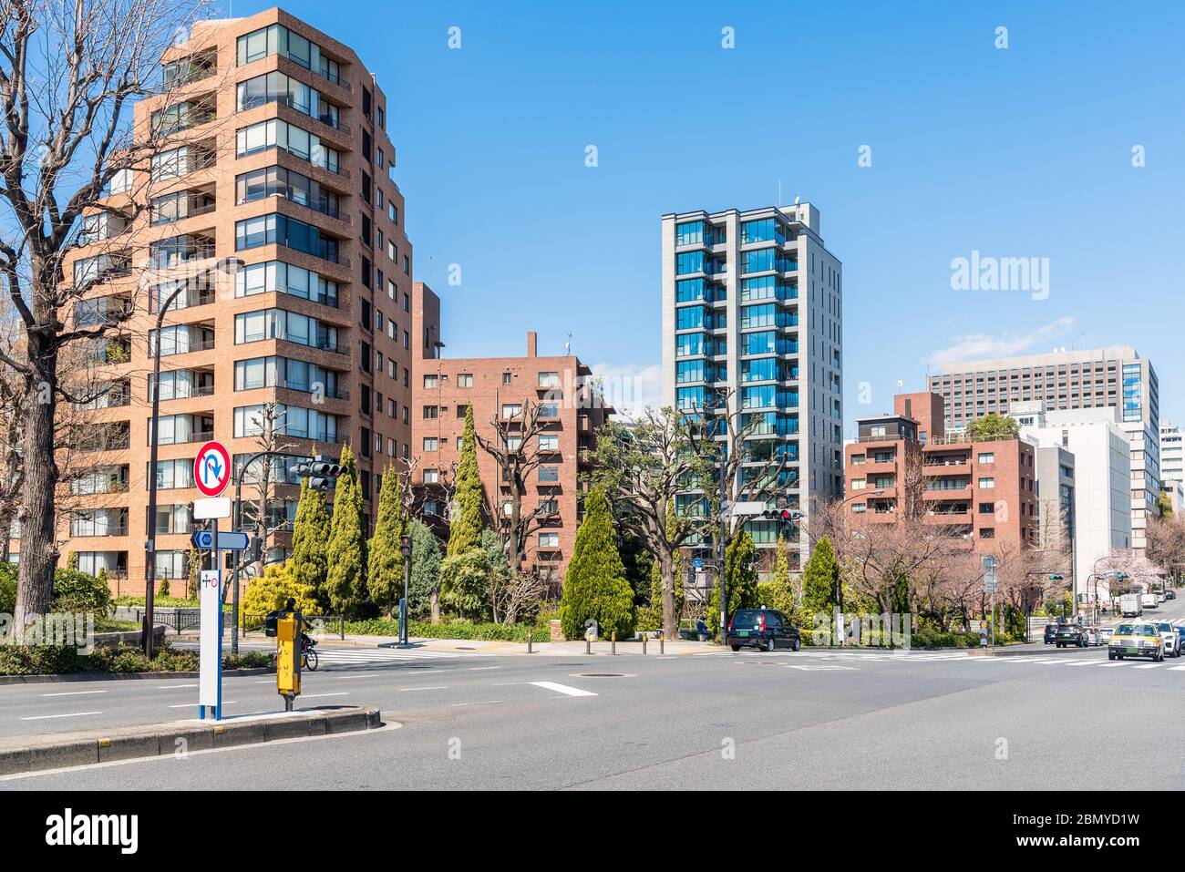 Apartment buildings in a residential district in Tokyio on a clear early spring day. An intersection with traffic lights is in foreground. Stock Photo