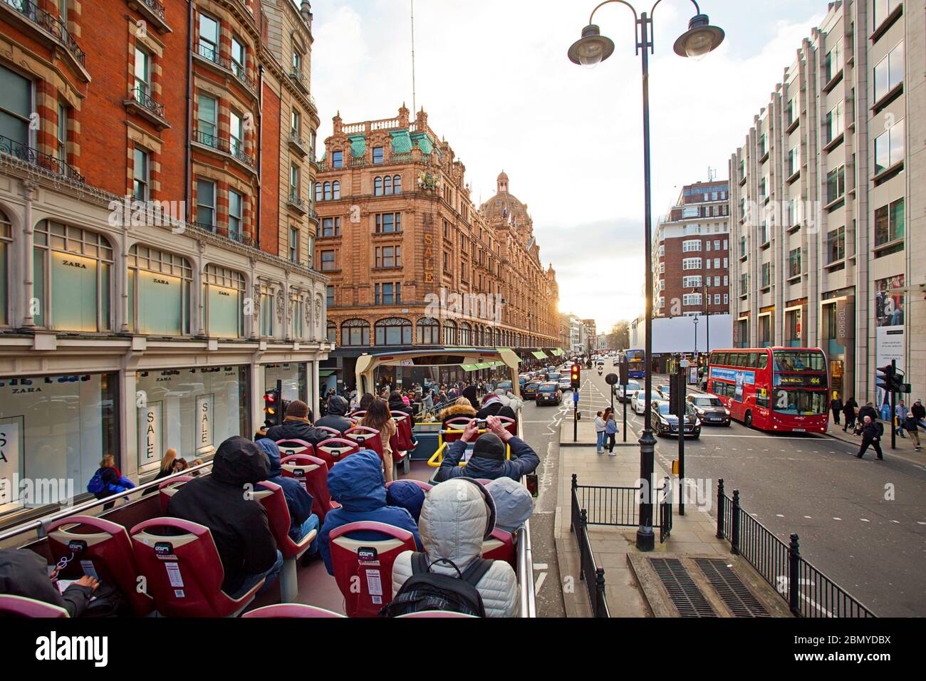 Red bus open deck tour down Brompton Road Stock Photo
