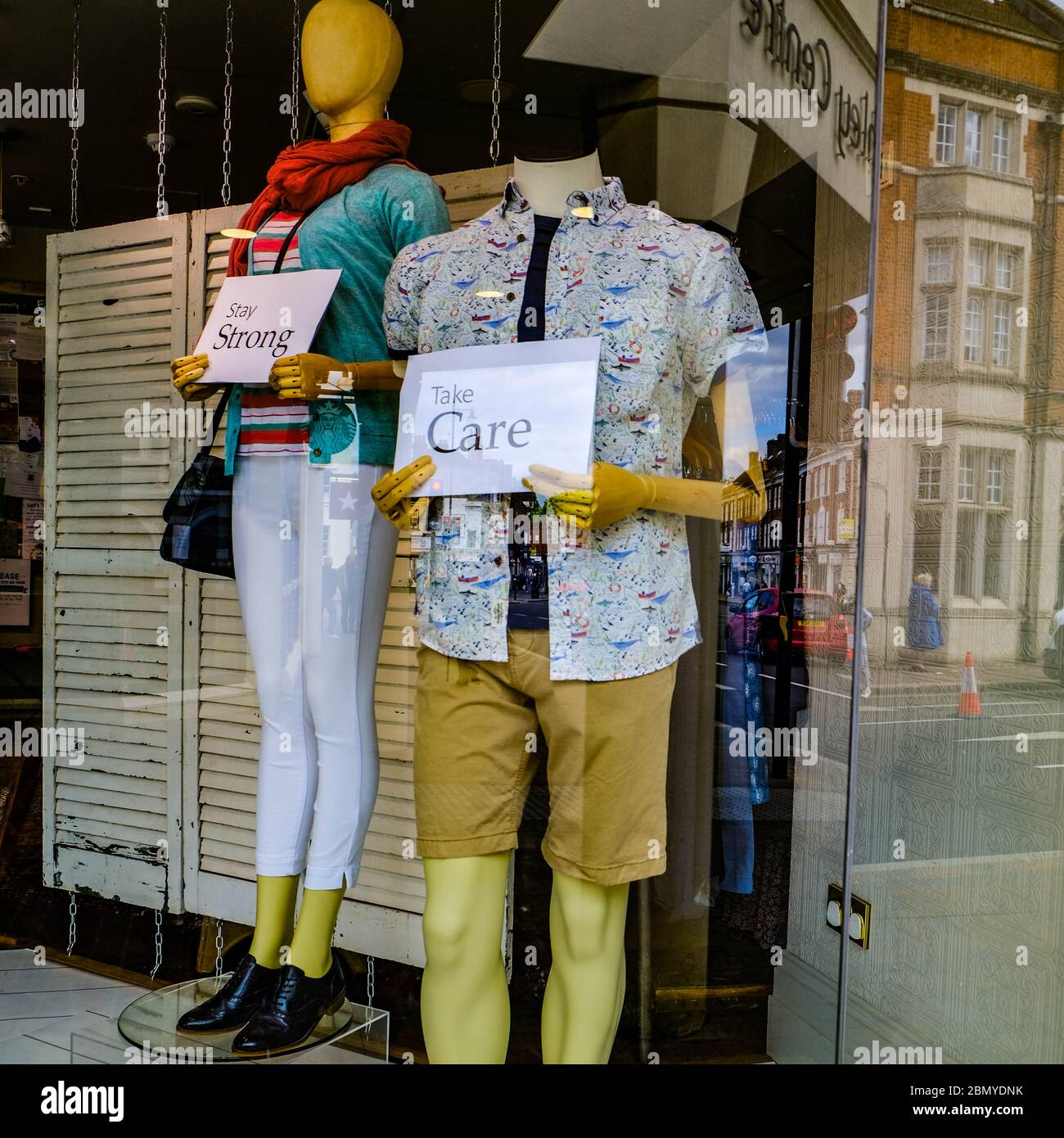 Two Shop Window Models Or Mannequins Holding  Keep Strong And Take Care Signs During The UK Coronavirus Pandemic 2020 Stock Photo