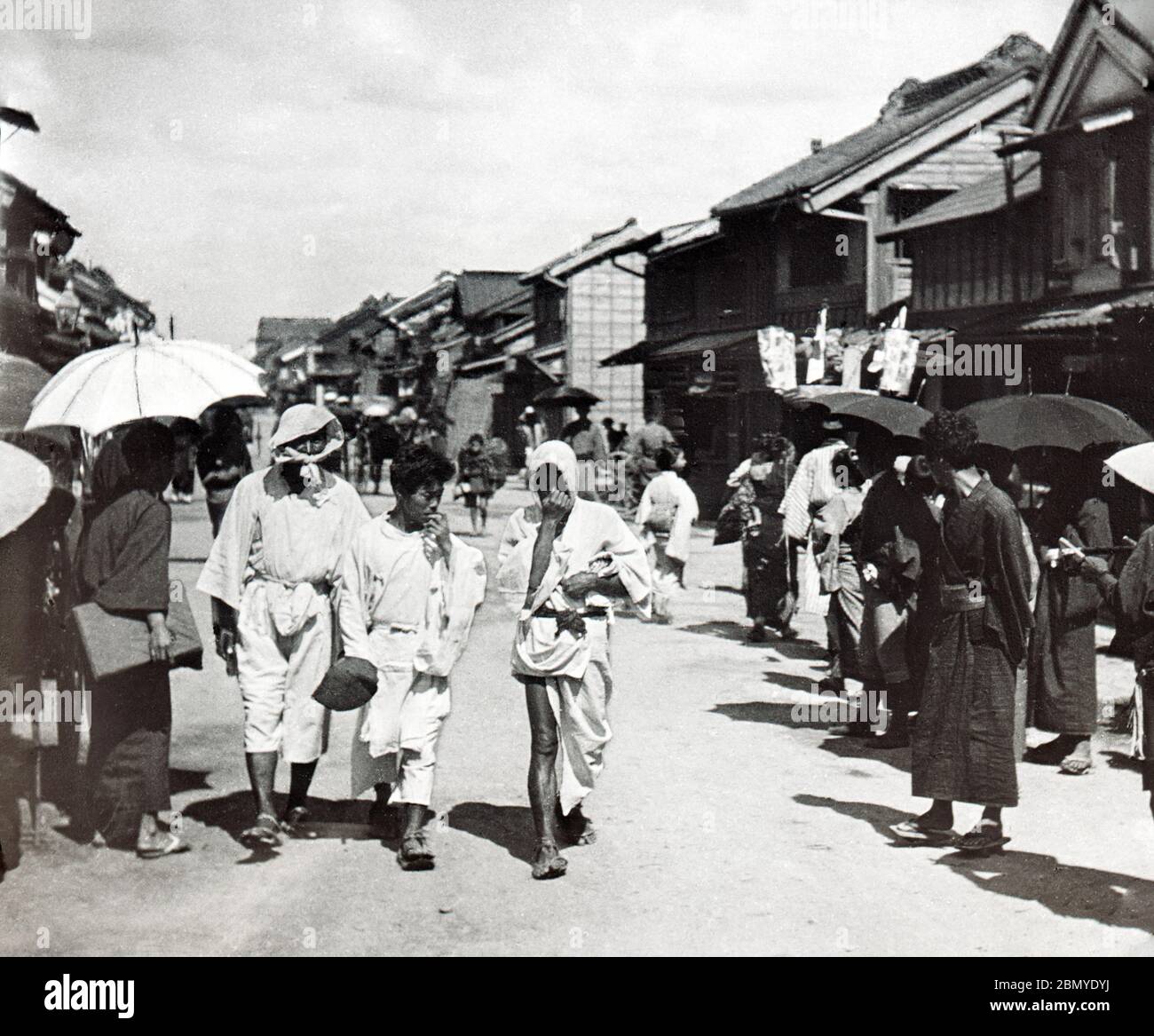 [ 1890s Japan - Returning from a Japanese Funeral ] —   Mutes returning from a funeral.  From a series of glass slides published (but not photographed) by Scottish photographer George Washington Wilson (1823–1893). Wilson’s firm was one of the largest publishers of photographic prints in the world.  19th century vintage glass slide. Stock Photo