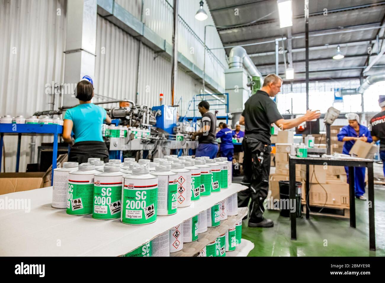 Johannesburg, South Africa - October 19, 2012: Diverse people working on an assembly line in a glue factory Stock Photo