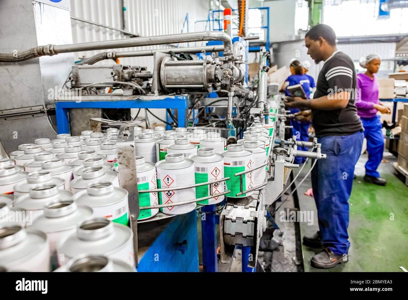 Johannesburg, South Africa - October 19, 2012: Diverse people working on an assembly line in a glue factory Stock Photo