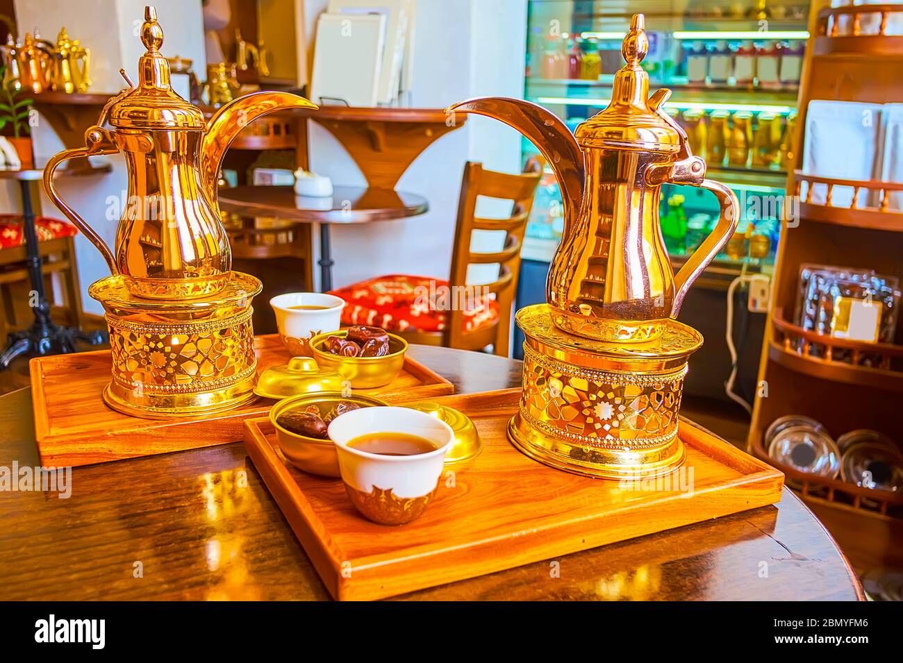 Enjoy delicious arabic qahwa coffee, made in brass dallah coffee pot with herbs and spices, Dubai, UAE Stock Photo