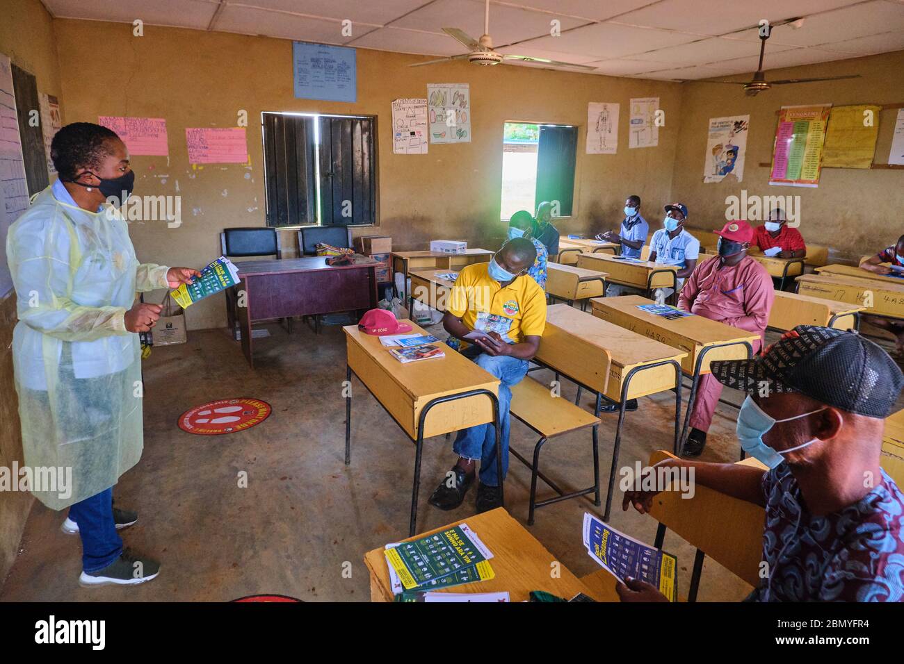 Teachers wearing PPE teach people donning face masks at a Social