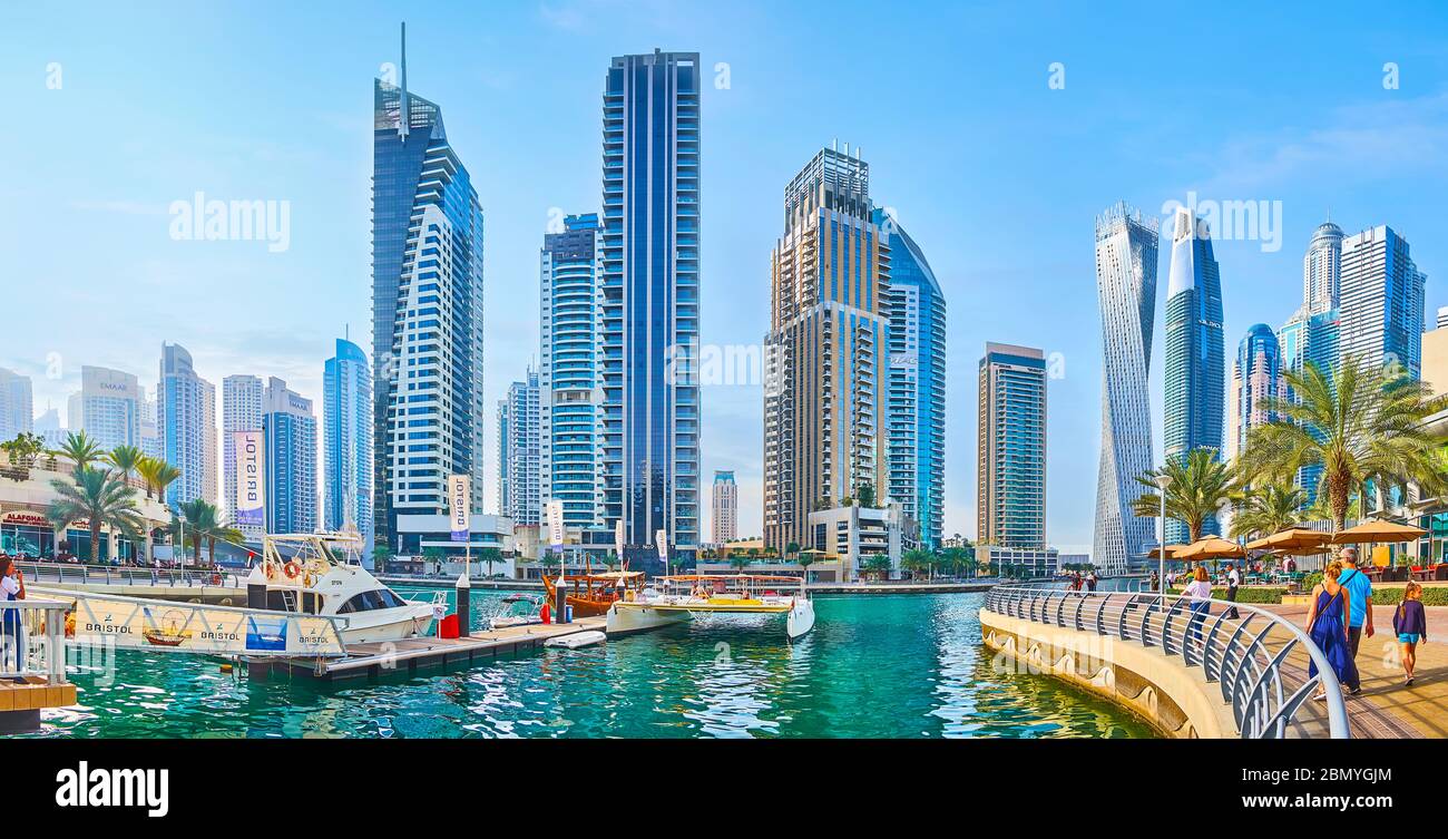DUBAI, UAE - MARCH 2, 2020: Watch the modern high rises of Dubai Marina from the harbor of Bristol Charter, surrounded by cafes and restaurants, on Ma Stock Photo