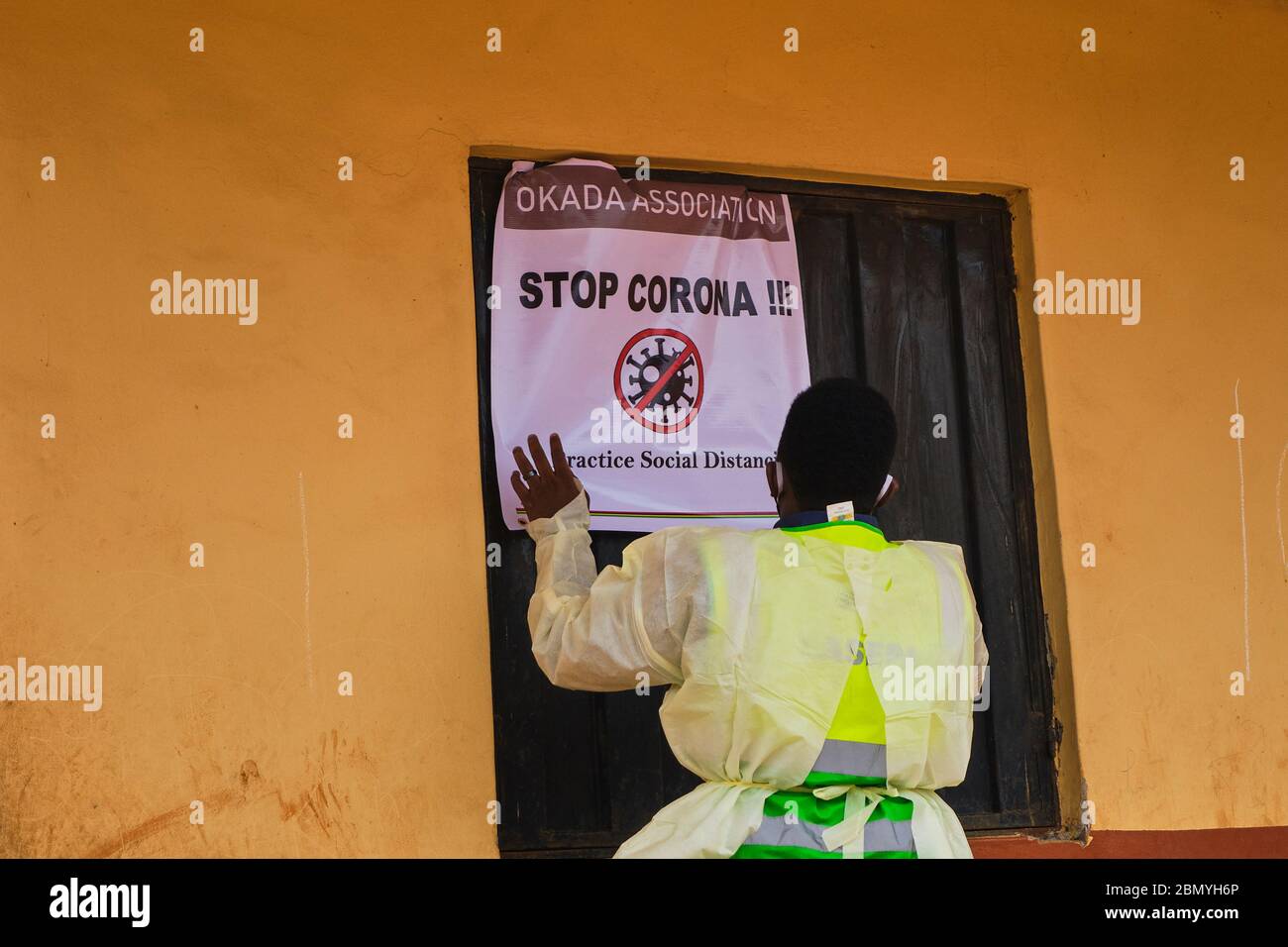 A man puts up a banner at a venue for a Social Distancing Advocacy program held by a government agency in Lagos, Nigeria. Stock Photo
