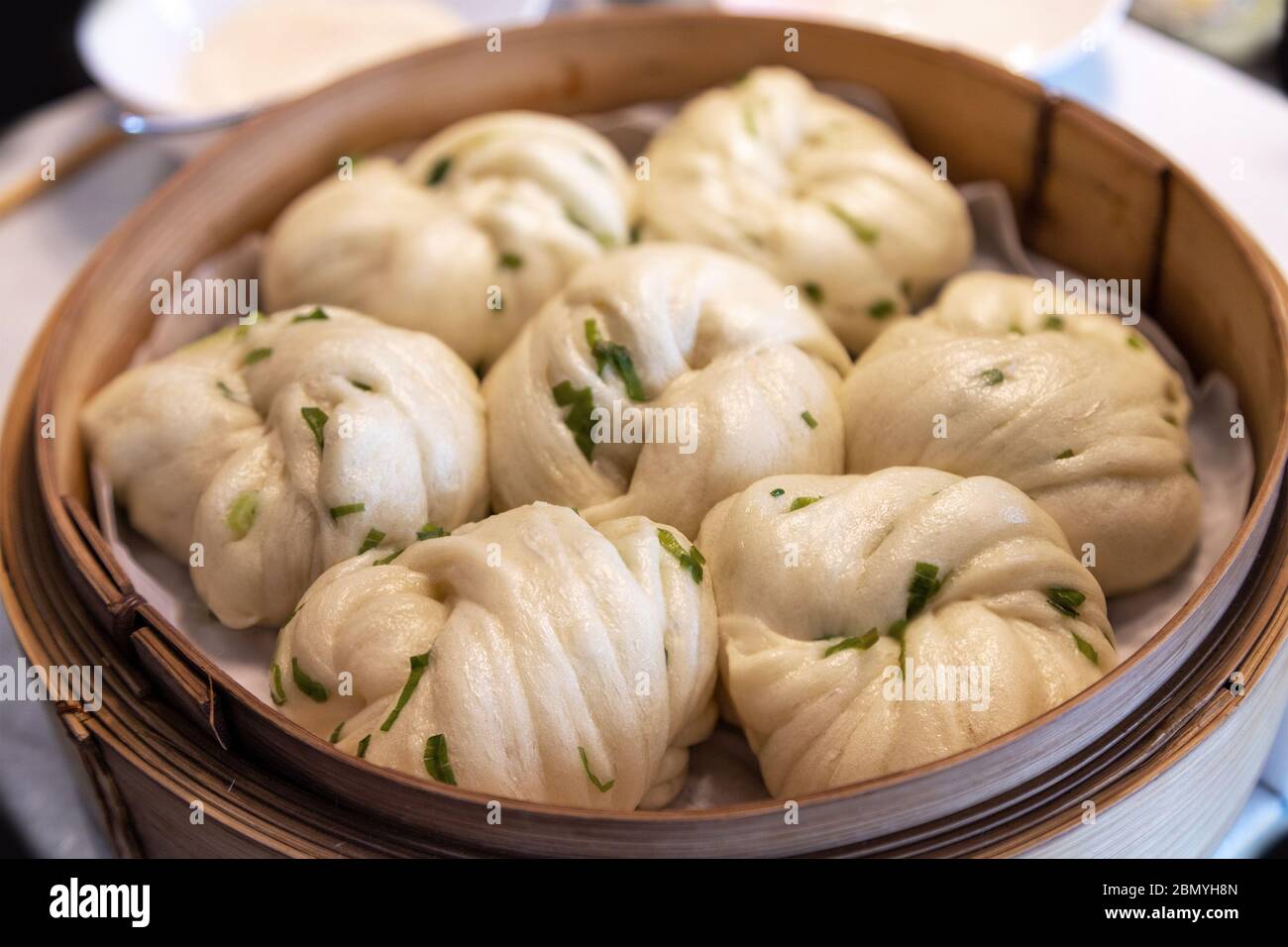 Chinese dim sum steamed scallion spring onion bun rolls served in a bamboo steamer. Dim sum is a unique culinary art form that originated with the Can Stock Photo