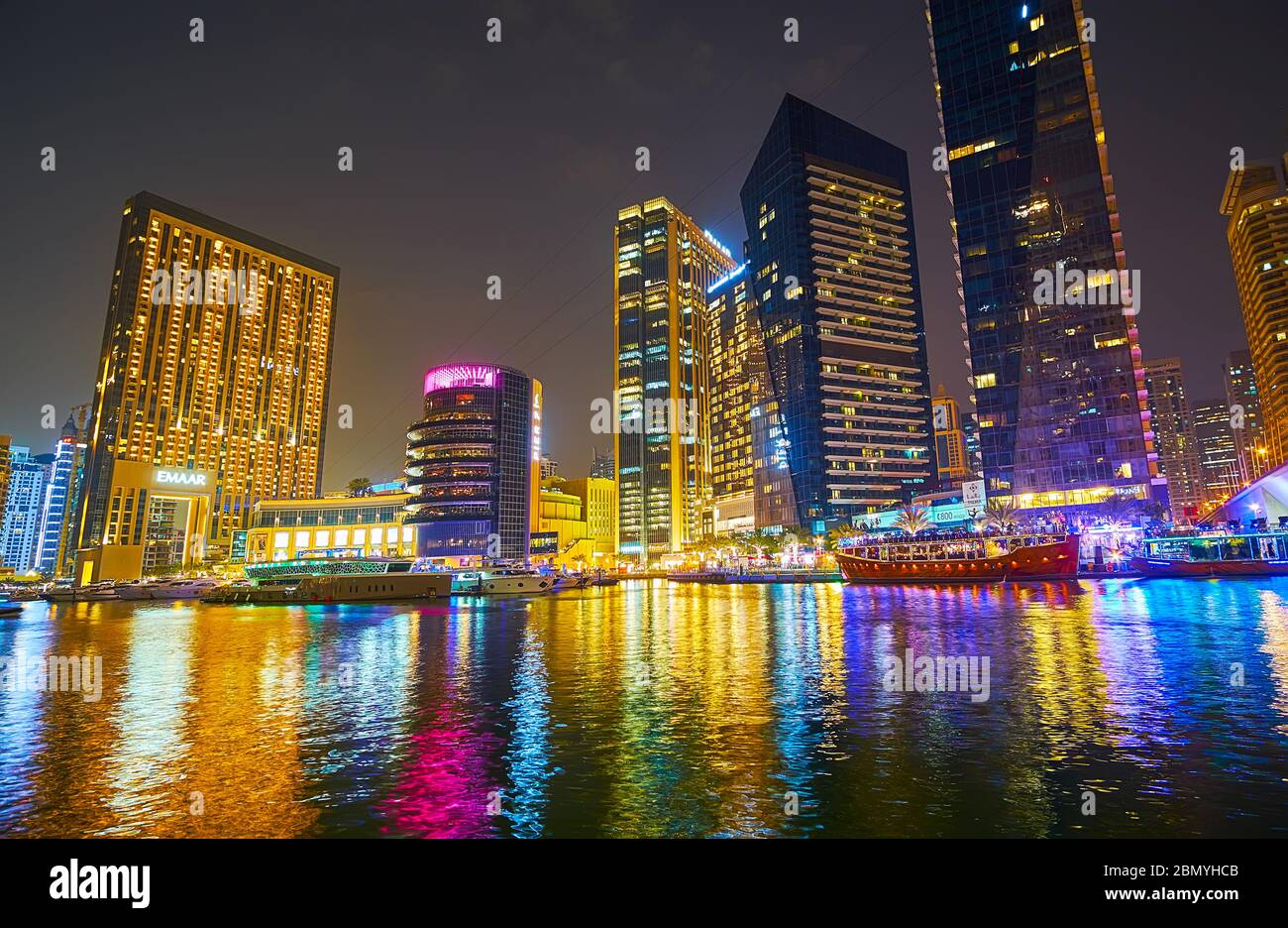 DUBAI, UAE - MARCH 2, 2020: Enjoy reflection of colorful illumination of glass skyscrapers, buildings of Address Dubai Marina, Pier 7 and Marina Mall, Stock Photo