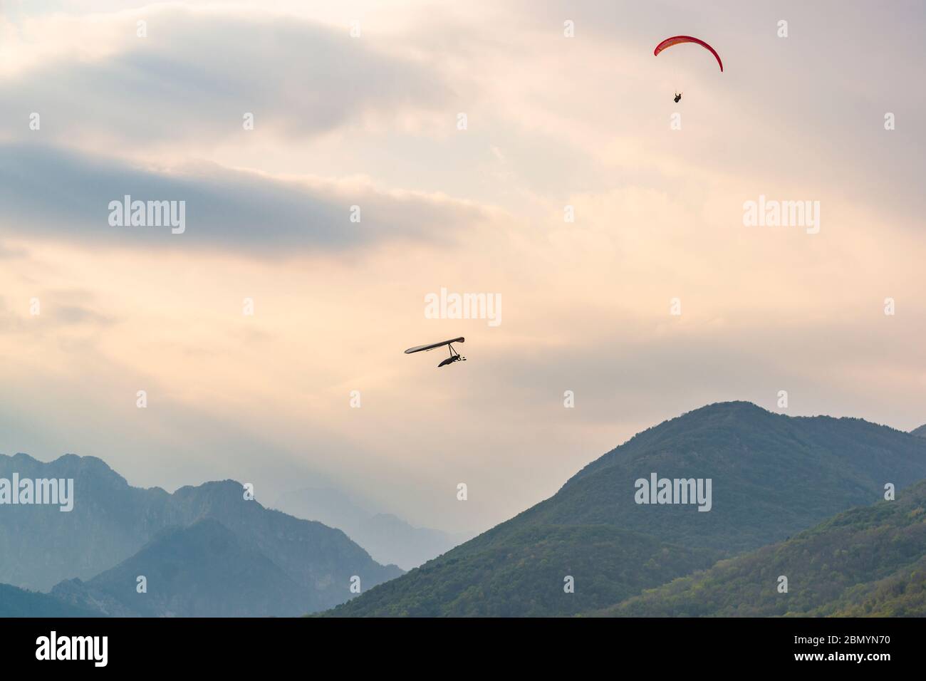 Hang glider and paraglider fly near Meduno in Pordenone, Italy Stock Photo