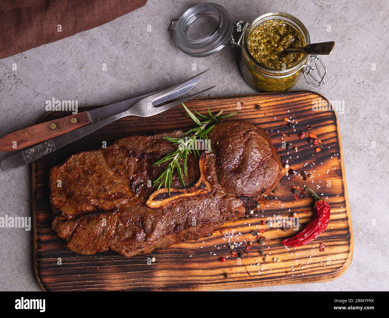grilled beef steak with bone on a cutting board,  spices Stock Photo