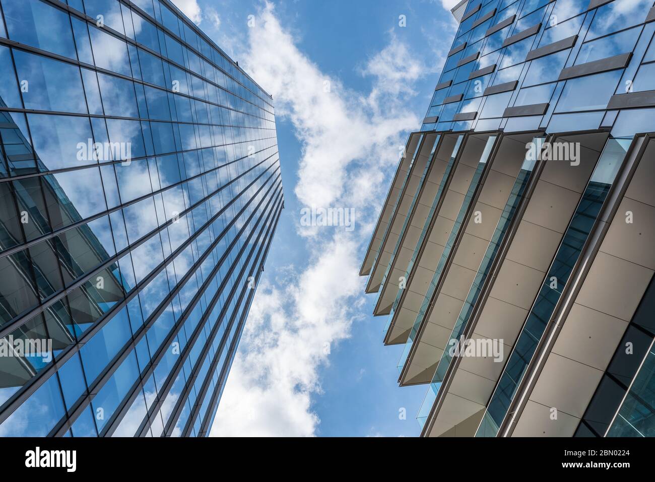 White clouds in a blue sky reflected in the windows of skyscrapers ...