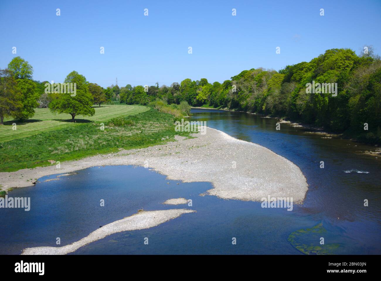 View east from Coldstream Bridge of the River Tweed, marking the Scotland England border here as it heads towards the North Sea at Berwick Stock Photo