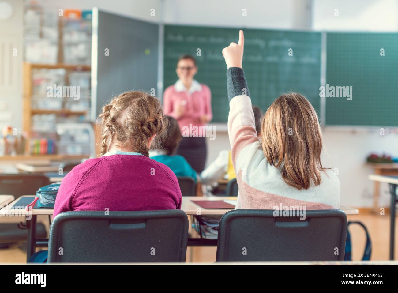 Teacher in school class with pupils sitting and listening Stock Photo